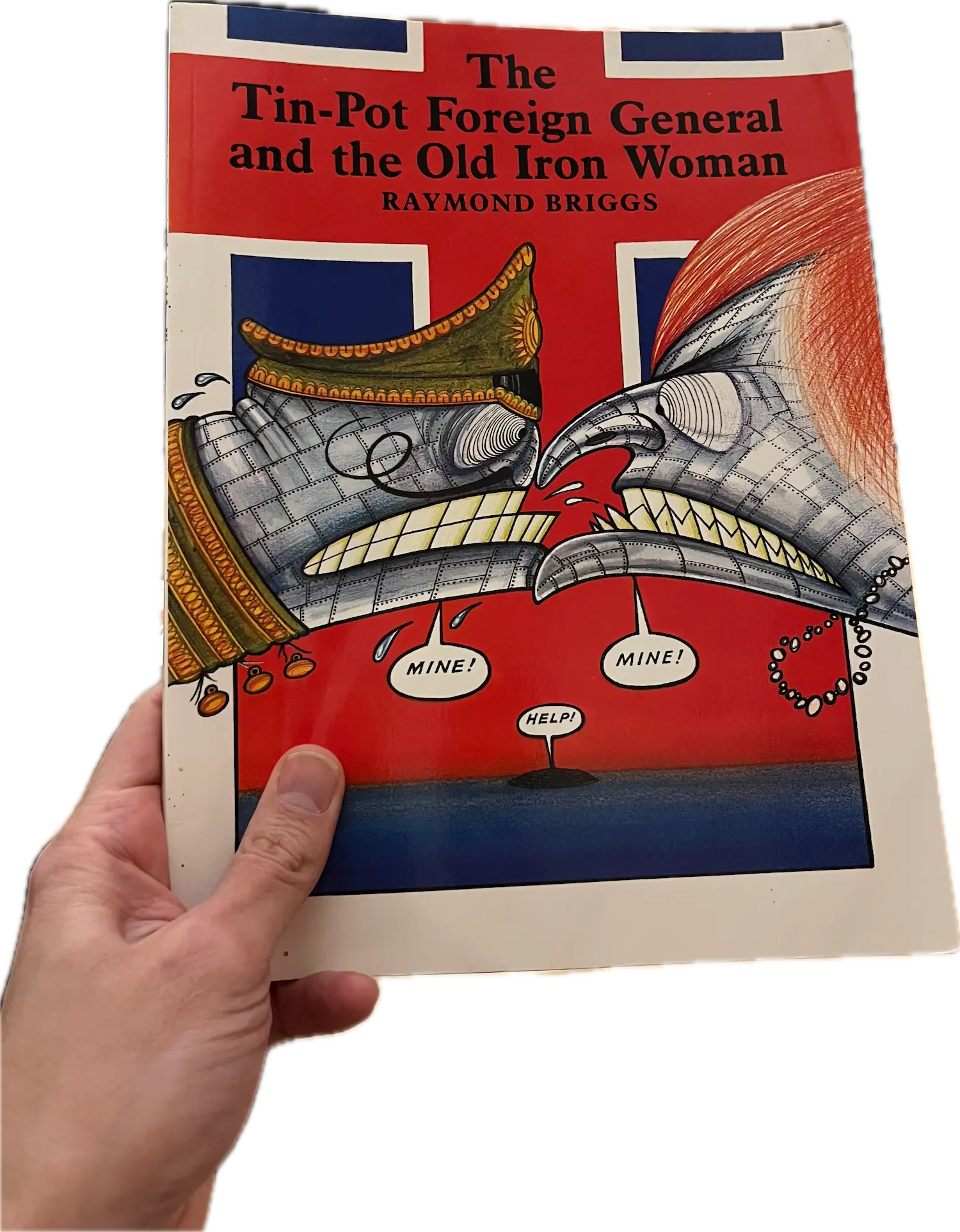 A hand holding a book, The Tin-Pot Foreign General and the Old Iron Woman